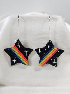 pair of black earrings with rainbow and stars