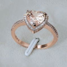 an engagement ring with a heart shaped morganite surrounded by diamonds