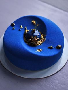 a blue cake with gold flakes on it