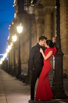 a man and woman standing next to each other near a street light