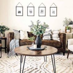 a living room with couches, chairs and pictures on the wall above them in black frames