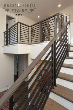 there is a stair case in the middle of this room with wood and metal railings