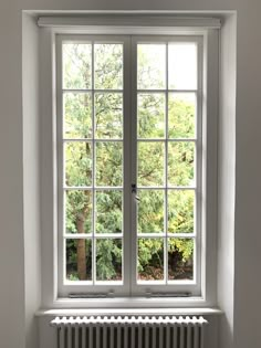 an empty room with a window and radiator