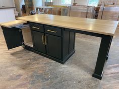 a kitchen island with black cabinets and gold handles