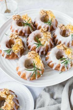 a white plate topped with donuts covered in icing and toppings on top of a table