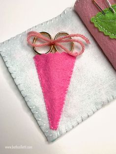 two pieces of felt with pink and green designs on them sitting next to each other