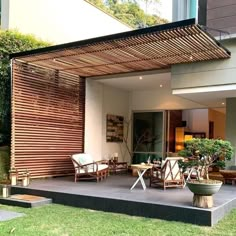 an outdoor living area with wooden slats on the wall and grass in the foreground