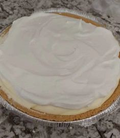 a pie with white frosting sitting on top of a counter