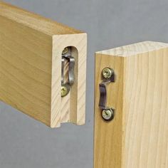 a close up of a wooden door hinge with two metal latches on it