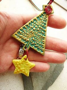 a hand holding a yellow and green christmas tree ornament