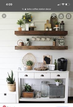 a white table topped with potted plants next to two wooden shelves filled with pots