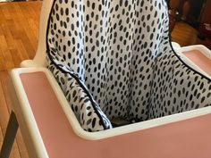 a baby's highchair with black and white polka dots on the fabric