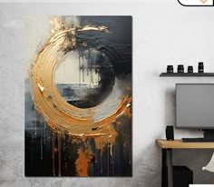 an abstract painting with gold and black paint splattered on the wall next to a computer desk