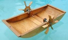 an old fashioned wooden boat floating on top of water with propellers attached to the front