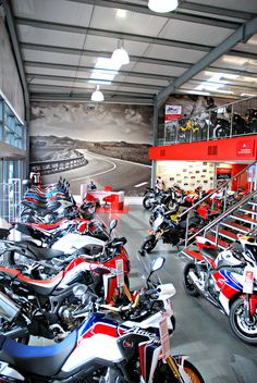 many motorcycles are parked in a large room with red, white and blue stripes on the walls