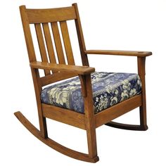 a wooden rocking chair with a blue floral seat cushion