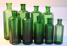 several green glass bottles lined up in a row