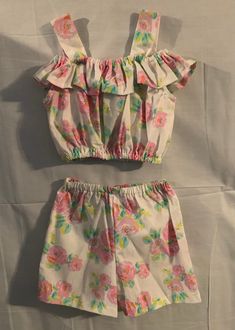 Two piece floral short set/ top is off the shoulder straps with a ruffle. Mid-knee length shorts with elastic waist. Two Piece Short Set, Knee Length Shorts, Floral Short, Short Set, Girl Dresses, May 1, Short Sets, Shoulder Straps