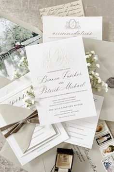 the wedding stationery is laid out on top of an envelope and some other items