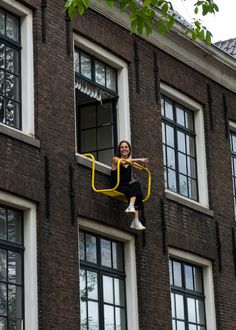 a woman in black and white jumps up into the air from a window