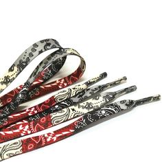 four lanyards are lined up on a white surface and one is red, the other has black and white designs