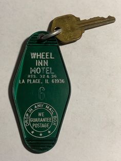 a green keychain with the words wheel inn motel on it's side