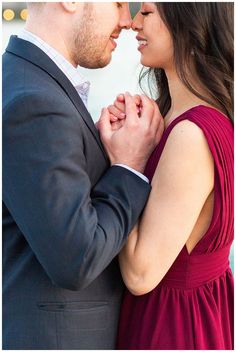 a man and woman standing next to each other with their arms around each other as they hold hands