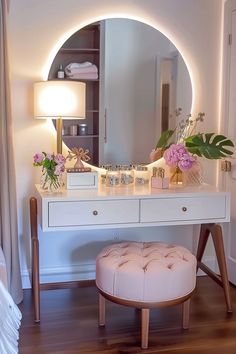 there is a vanity with flowers on it and a stool in front of the mirror