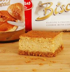 a piece of cake sitting on top of a wooden cutting board next to a bag of biscuits