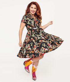 This sassy swing dress is crafted in a black cotton fabric complete with a western style motif including cactus, horses, and pin-up style cowgirls throughout. The shirt dress style bodice features a button front that leads to a classic collar, all framed by short sleeves. .Crinoline added for volume, sold separately..Available in sizes S-4X while supplies last. | Black & Cowgirl Print Swing Shirt Dress | Size Xlarge Cowgirl Print, Black Cowgirl, Jitterbug, Black Cotton Fabric, Dress Unique, Shirt Dress Style, Pin Up Style, Unique Dresses, Western Style