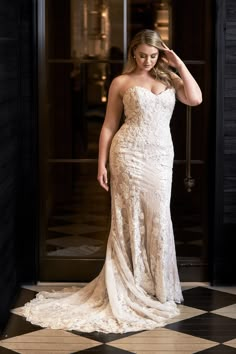 a woman in a white wedding dress standing on a black and white checkered floor