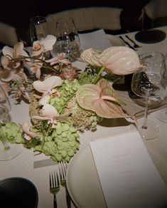 the table is set with flowers and place settings