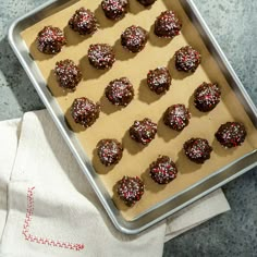 a pan filled with chocolate truffles covered in sprinkles on top of a table