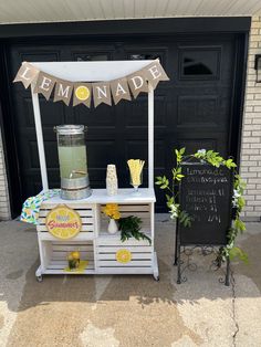 a lemonade stand is set up in front of a garage door for a lemonade party