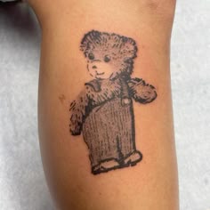 a small teddy bear tattoo on the leg