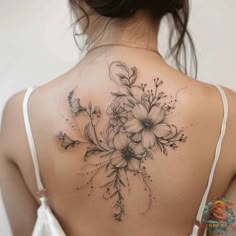 the back of a woman's shoulder with flowers and leaves on her left side