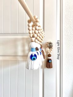 the door handle is made out of wood beads and tassels with blue eyes on them