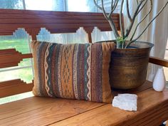 a wooden bench with a decorative pillow on it