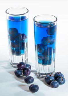 two glasses filled with blueberries next to each other