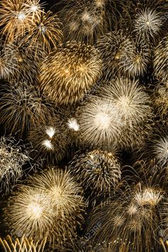 many fireworks are lit up in the night sky with gold and white colors stock photo