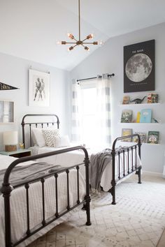 a bed room with a neatly made bed and a chandelier hanging from the ceiling