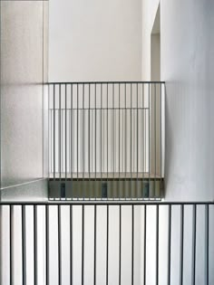 a cat is sitting on the floor in front of a window with bars around it