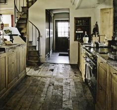 an old fashioned kitchen with wooden floors and stairs