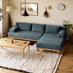 a blue couch sitting on top of a white rug next to a wooden coffee table