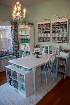 a white table and chairs in a room with lots of shelves on the wall behind it