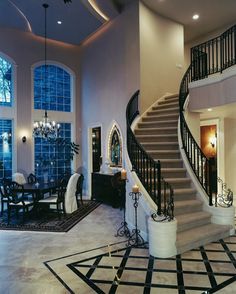 a large foyer with chandelier, table and chairs