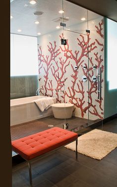 a modern bathroom with red coral wallpaper and white bathtub in the corner, along with an orange bench