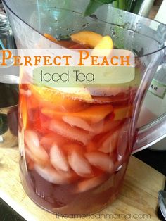 a pitcher filled with iced tea sitting on top of a table