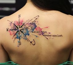 the back of a woman's shoulder with watercolor tattoos on it