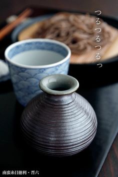 there are two vases on the table with chopsticks